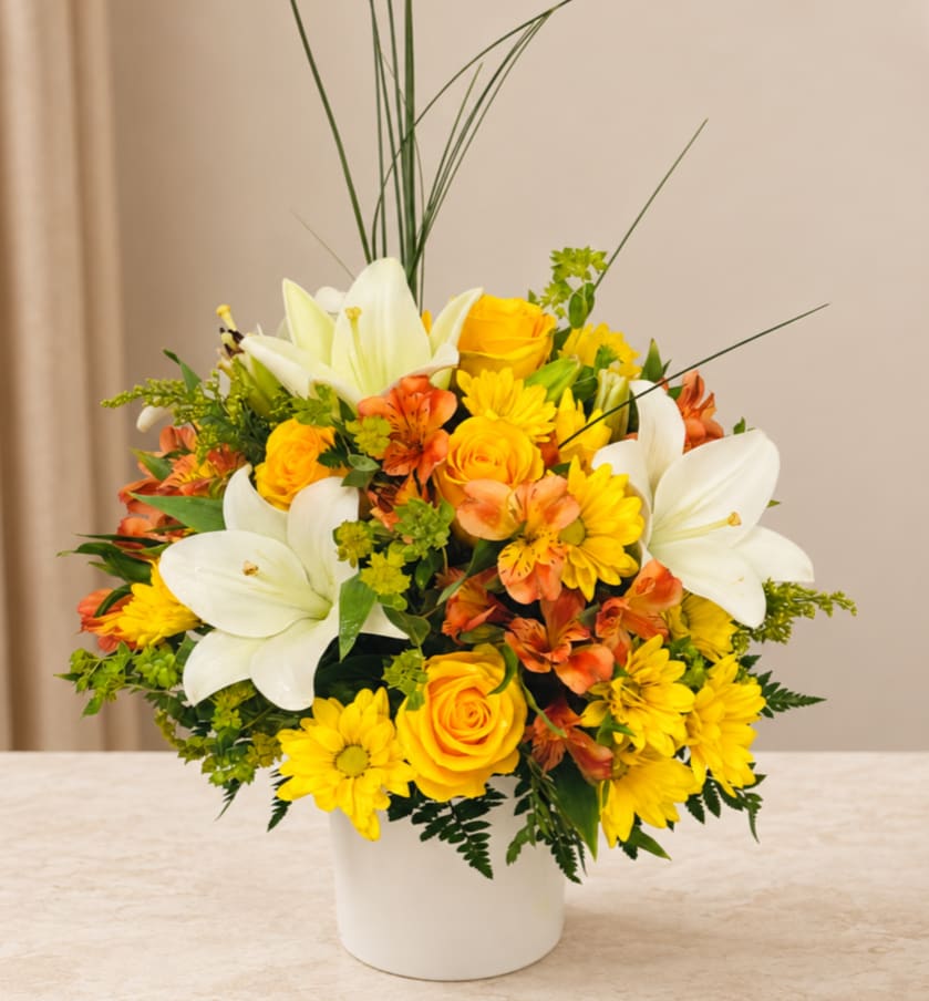 Yellow and white floral arrangement in a white vase