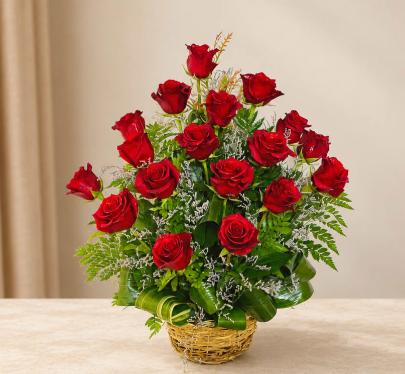 Basket arrangement of red roses with greenery and white filler