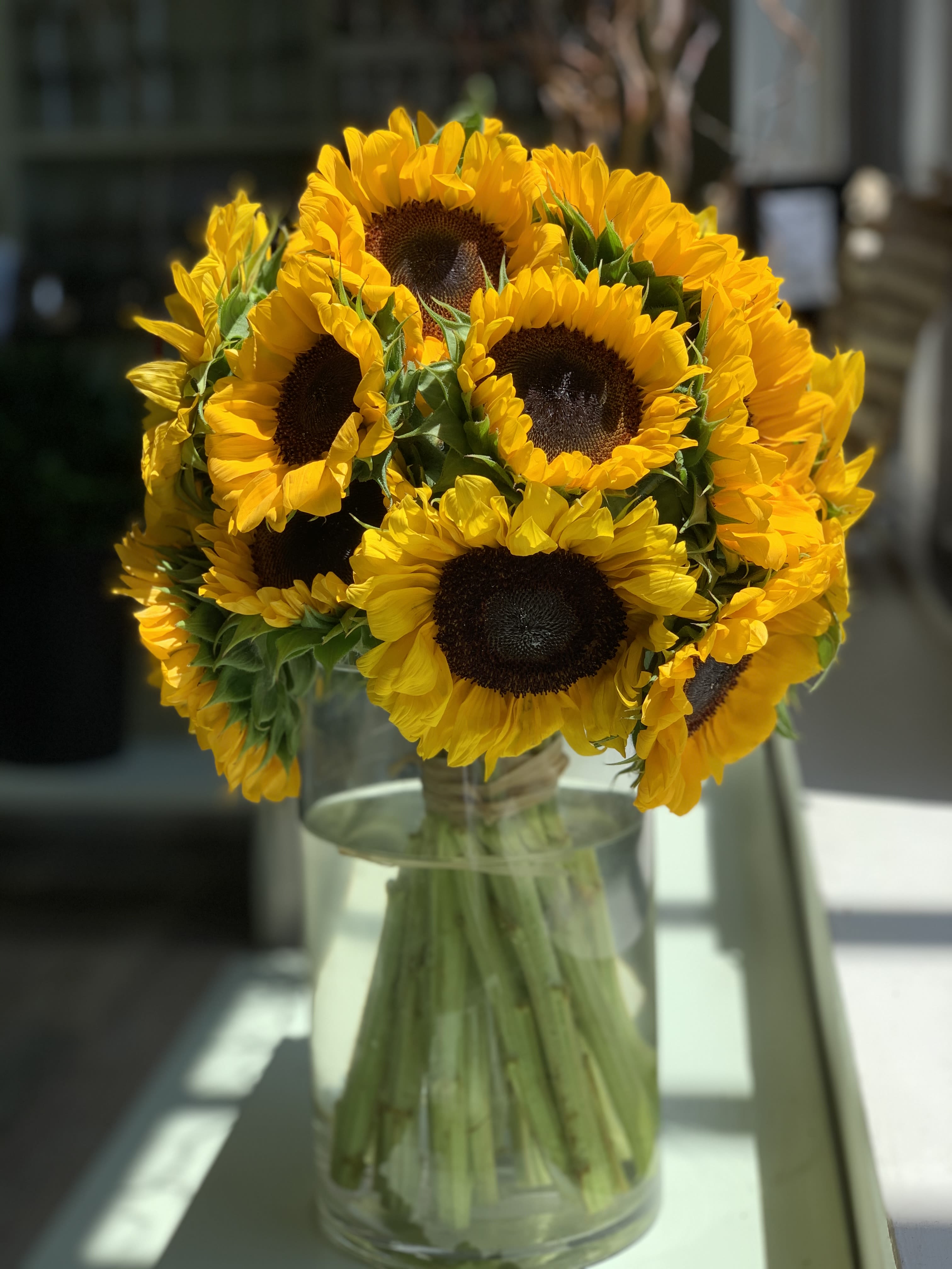 Bouquet of yellow sunflowers in a clear glass vase