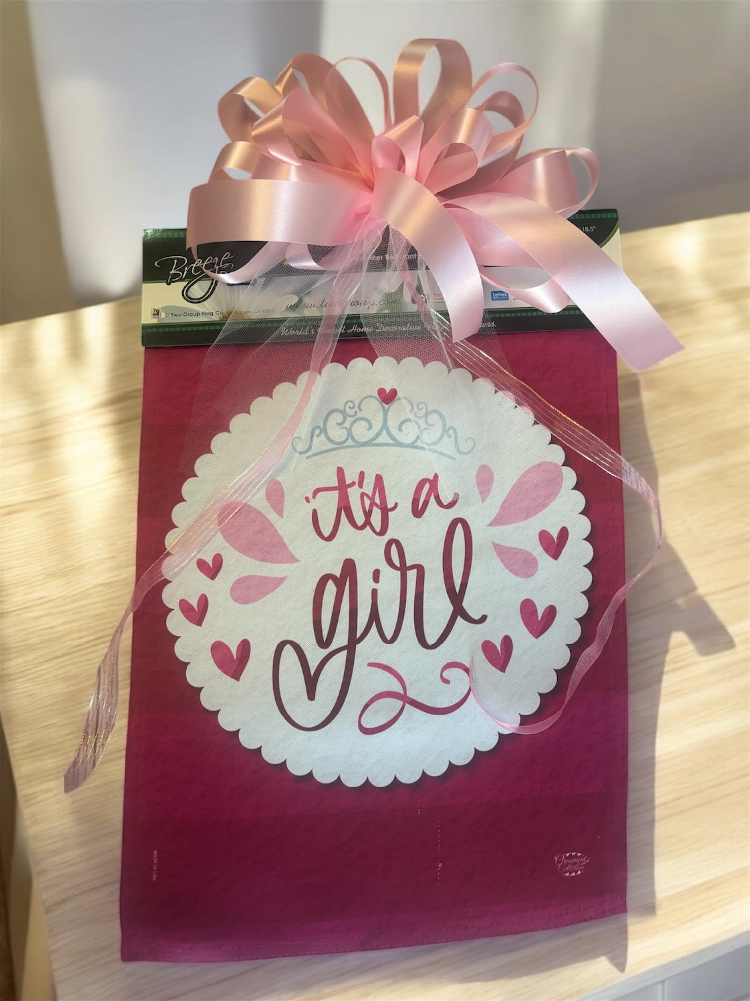 Pink gift bag with a large bow and "it's a girl" message