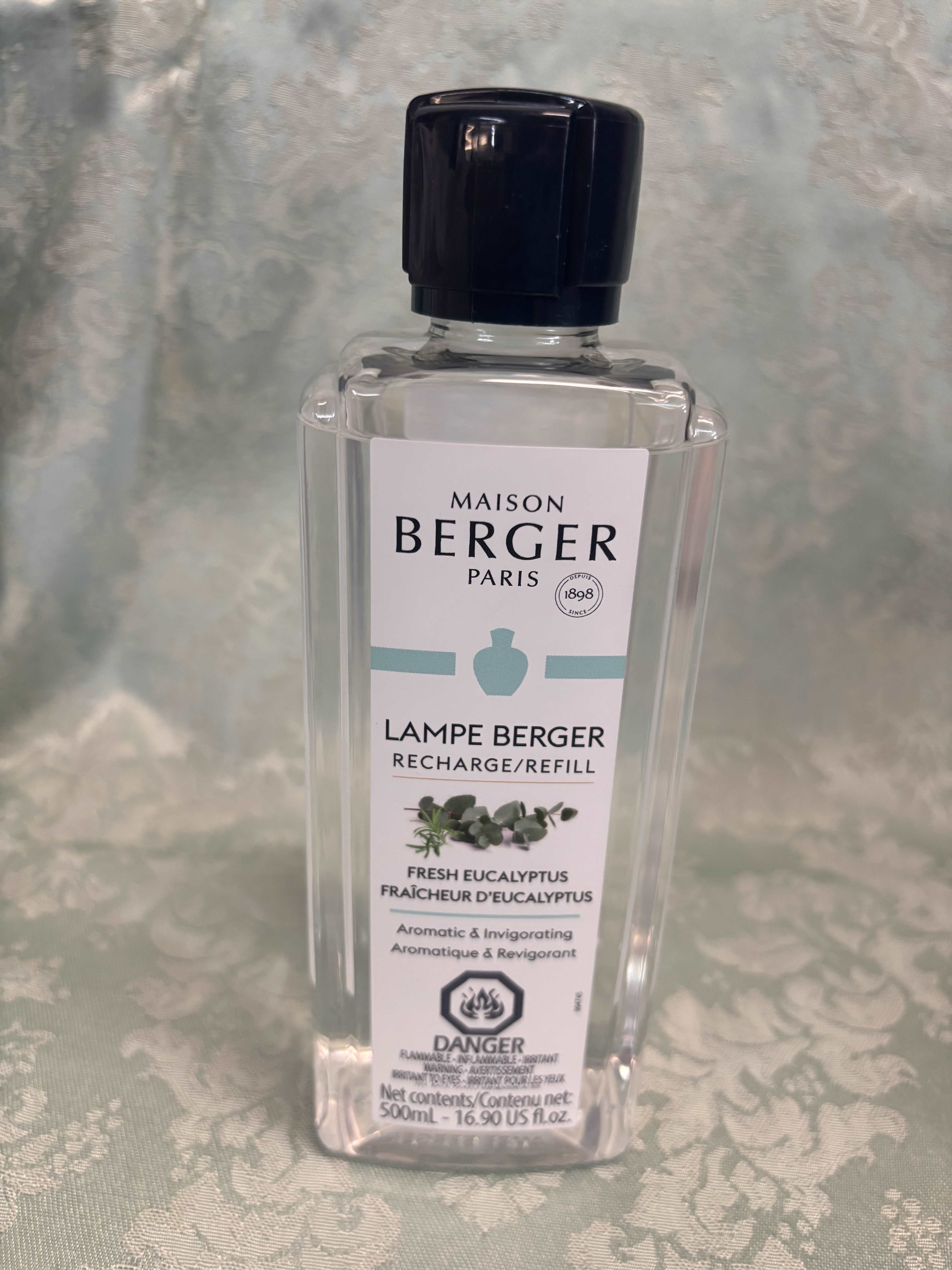 Clear bottle of Maison Berger eucalyptus lamp refill with a black cap