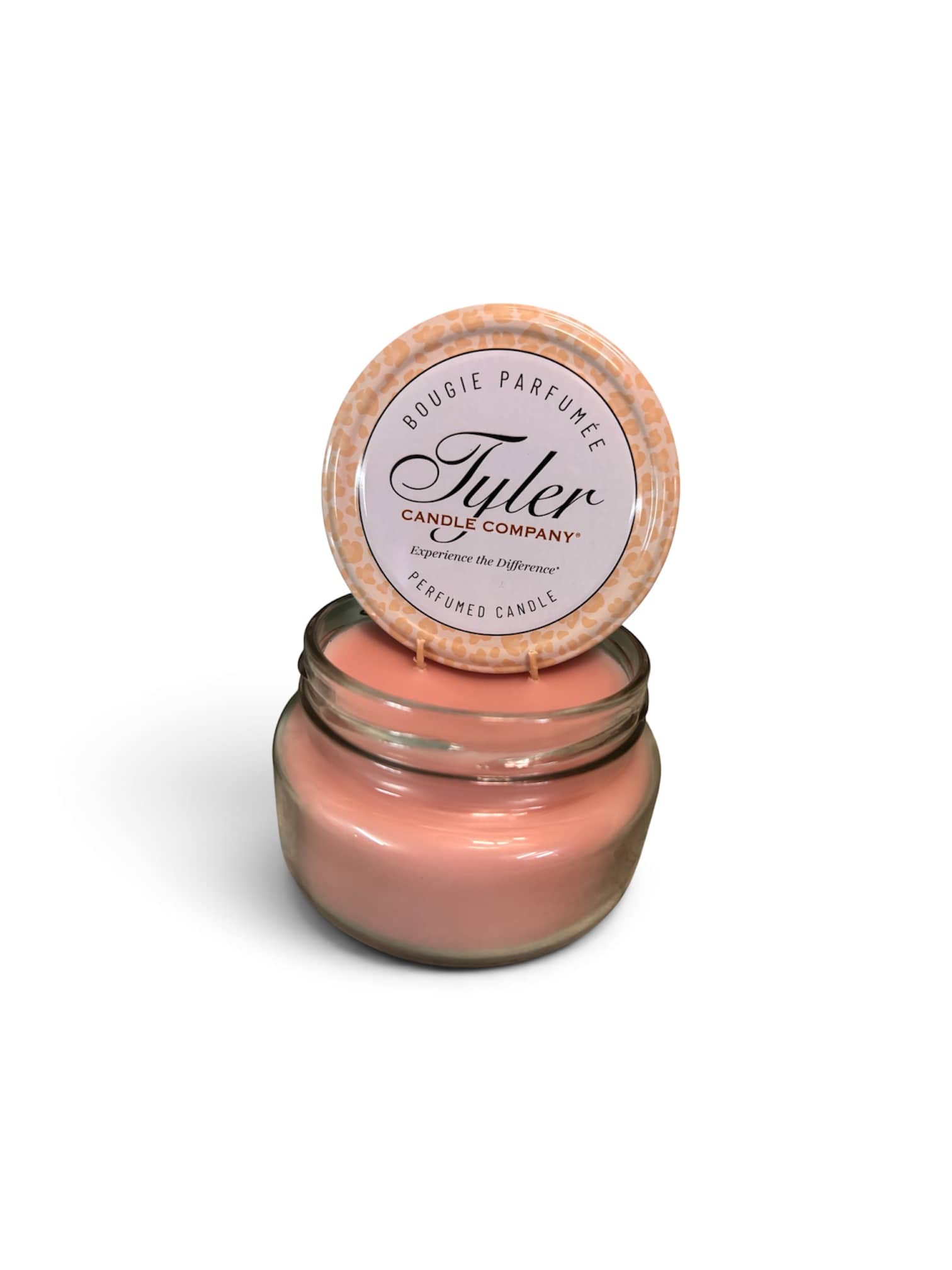 Pink scented candle in a glass jar with a lid