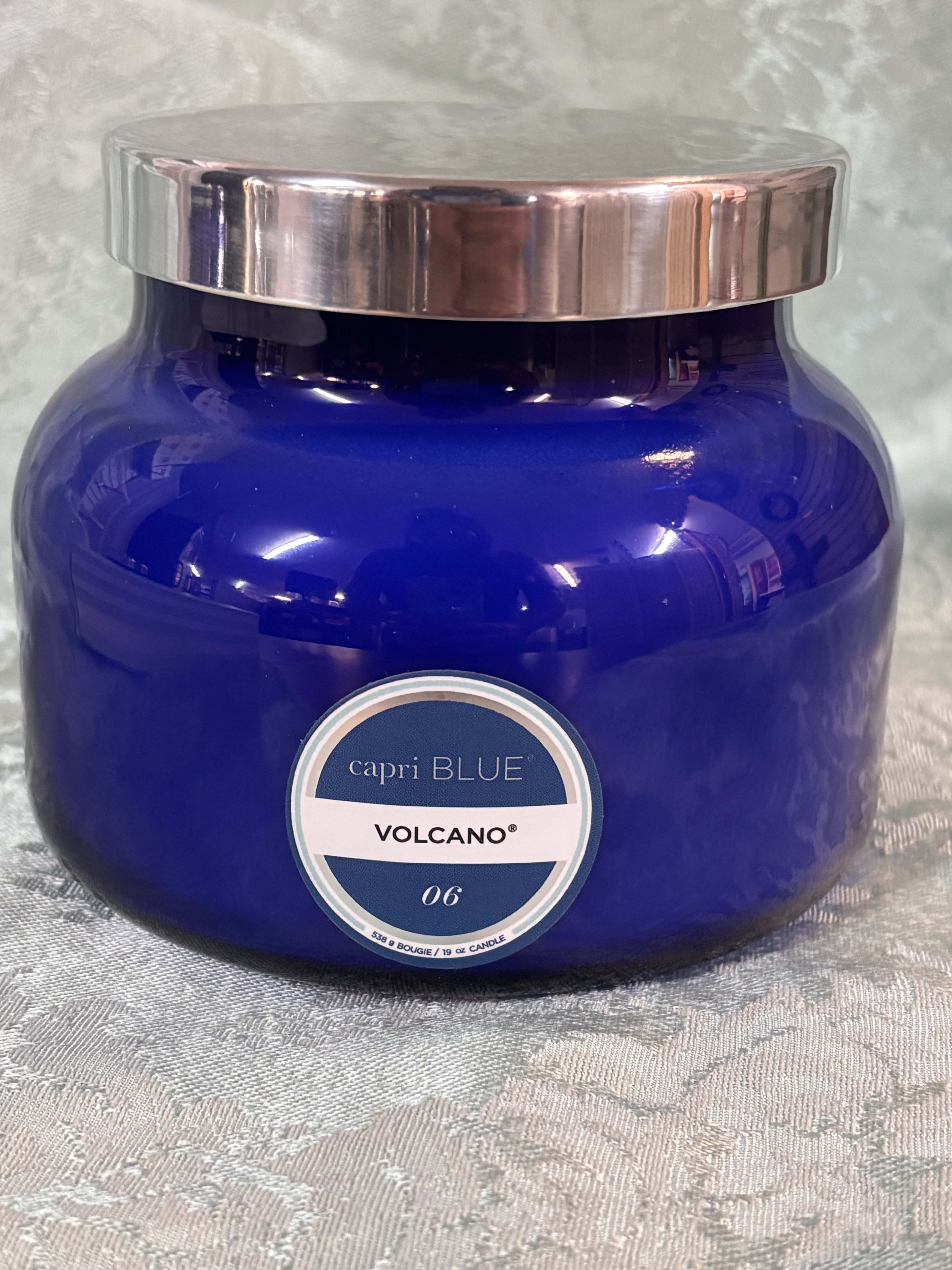 Blue glass candle jar with a silver lid and label