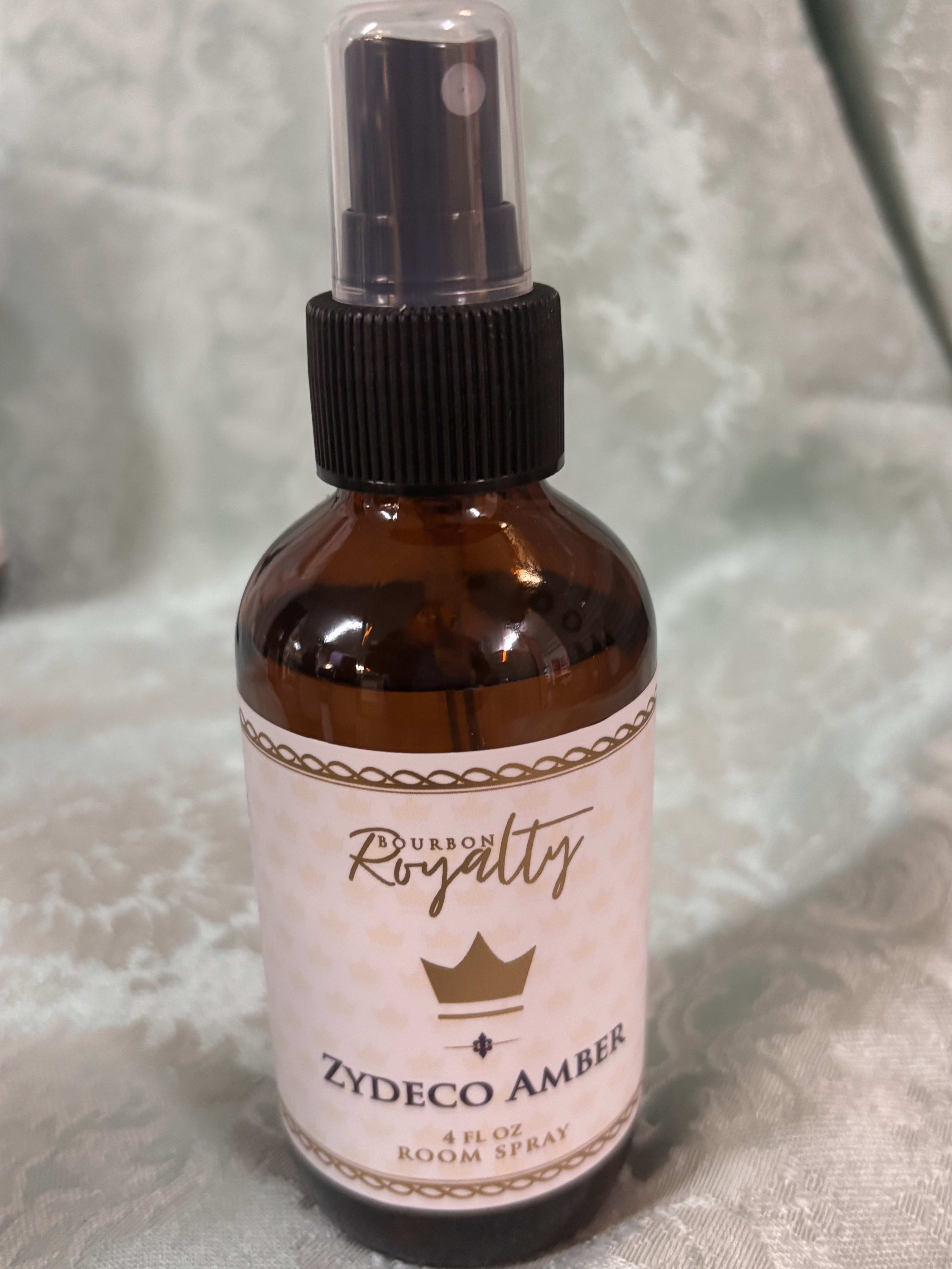 Amber room spray bottle with a pink label and black spray top