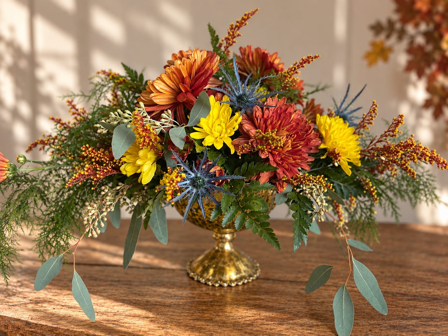 Autumn floral arrangement with chrysanthemums in a gold pedestal vase