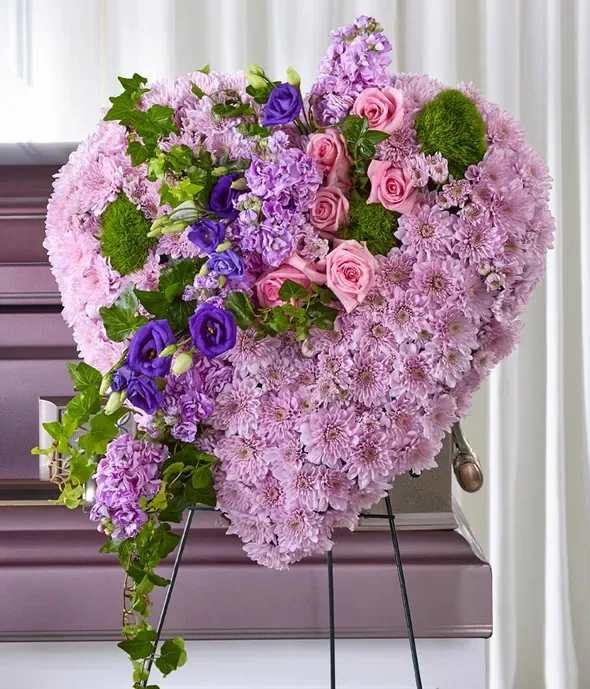 Heart-shaped floral arrangement in pink and purple flowers on an easel