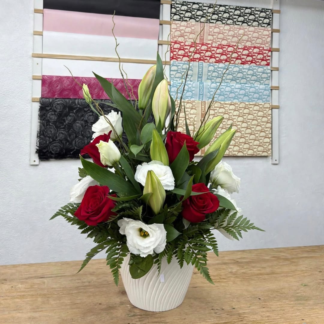 Red roses and white lilies arranged in a white vase