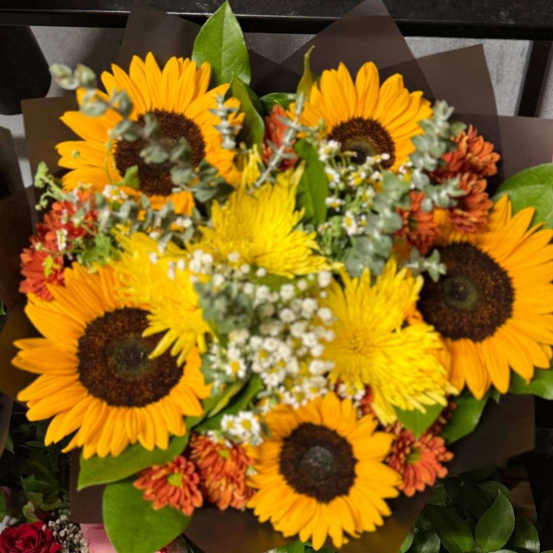 Bouquet of sunflowers and yellow mums with small white filler flowers