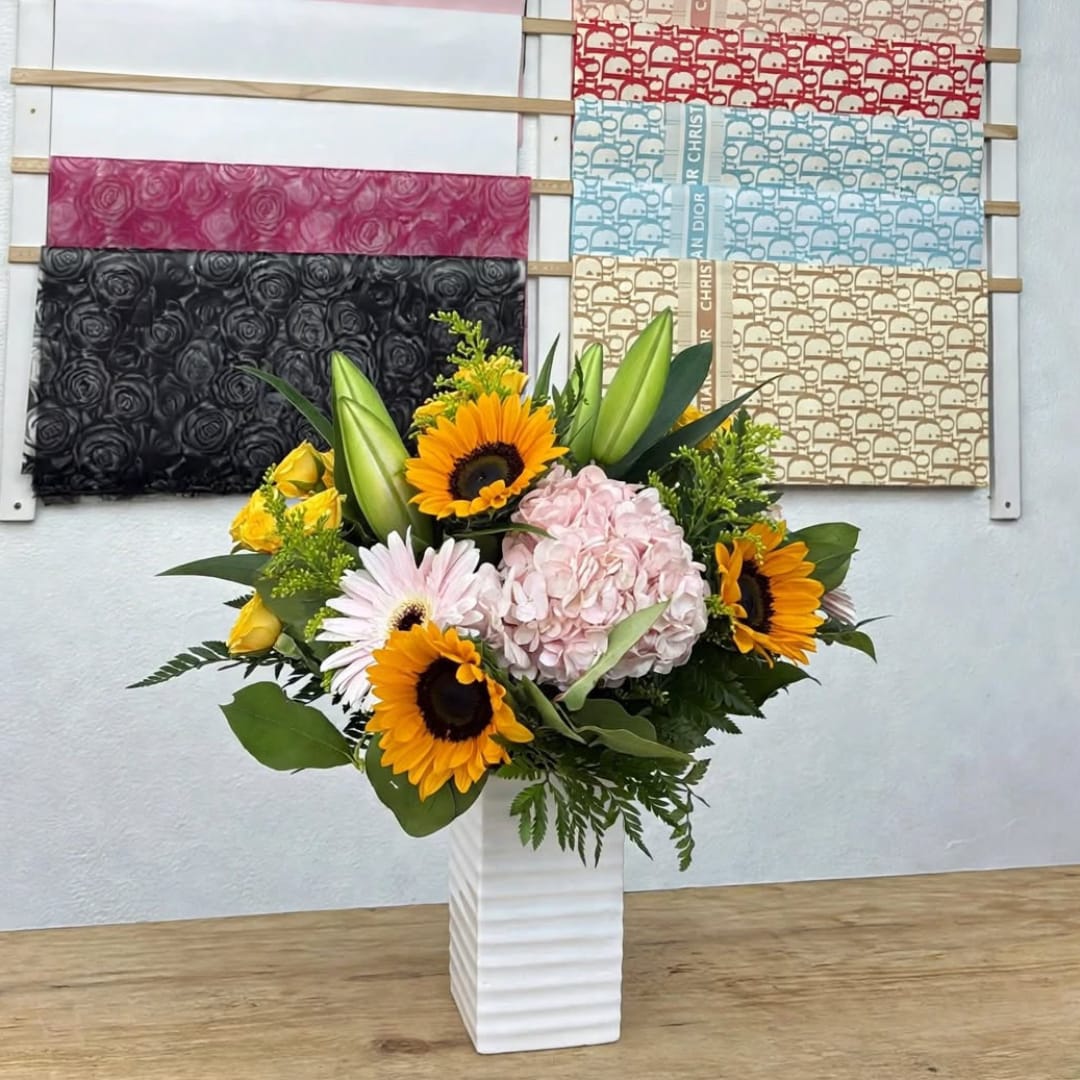 Sunflower and hydrangea arrangement in a white vase