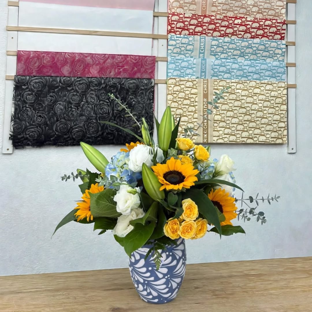 Sunflower and rose bouquet in a patterned vase