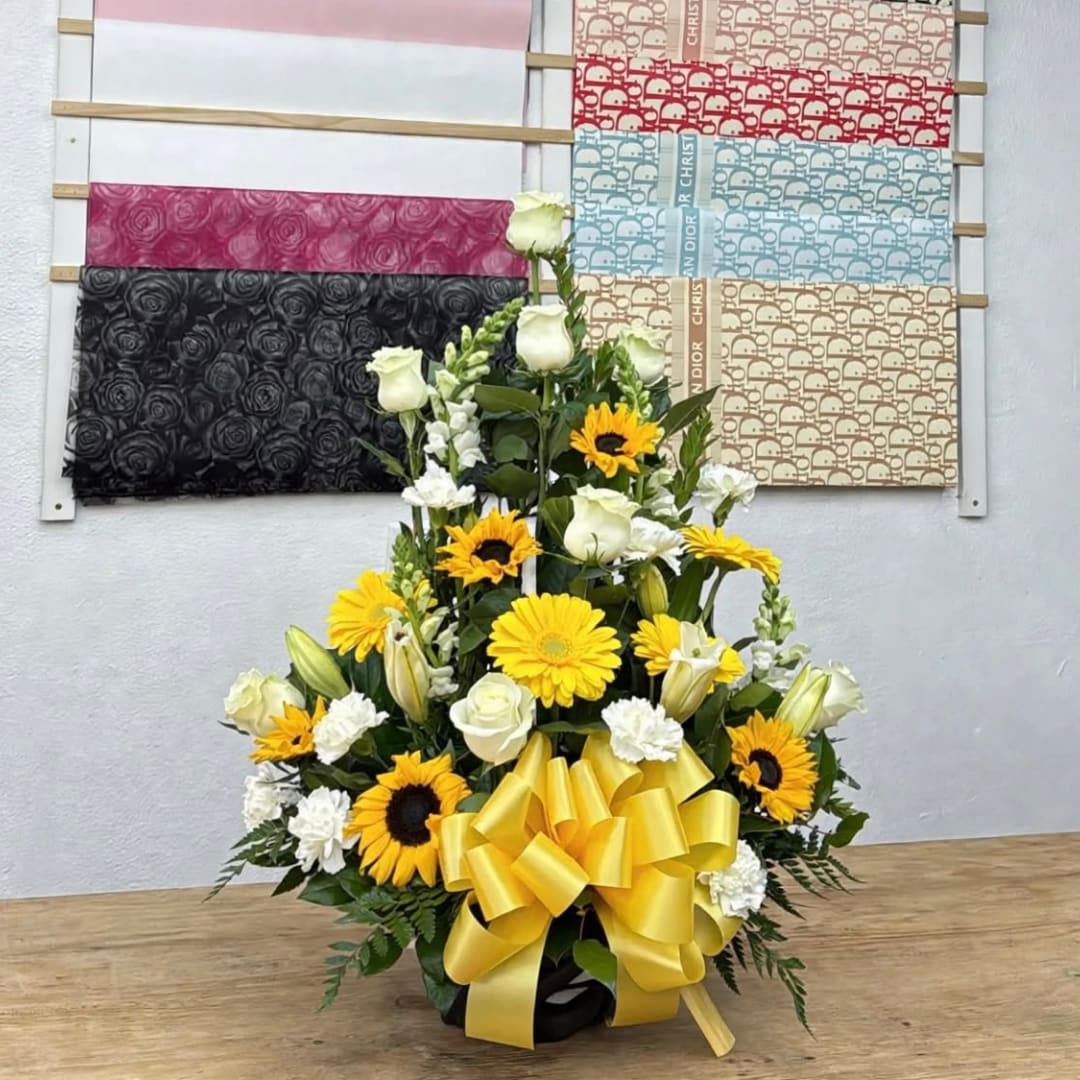 Yellow and white floral arrangement with a large yellow bow