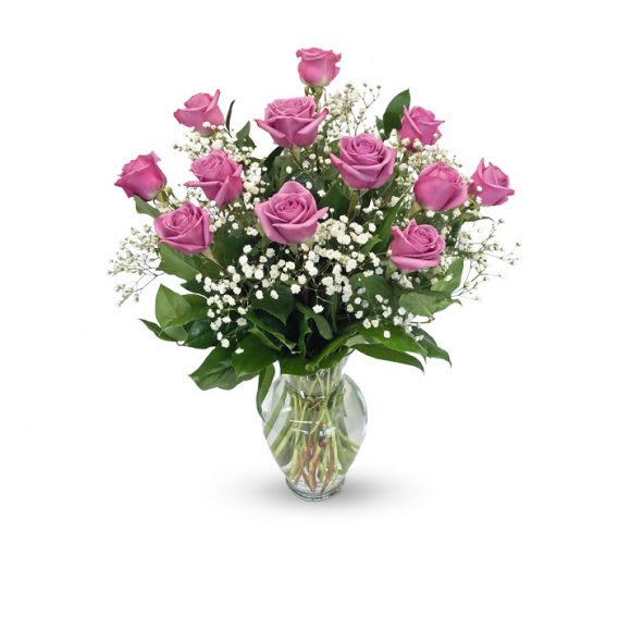 Pink roses arranged in a clear glass vase with white filler flowers