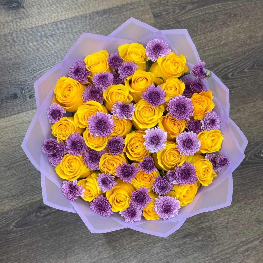 Yellow roses and purple chrysanthemums wrapped in lavender paper
