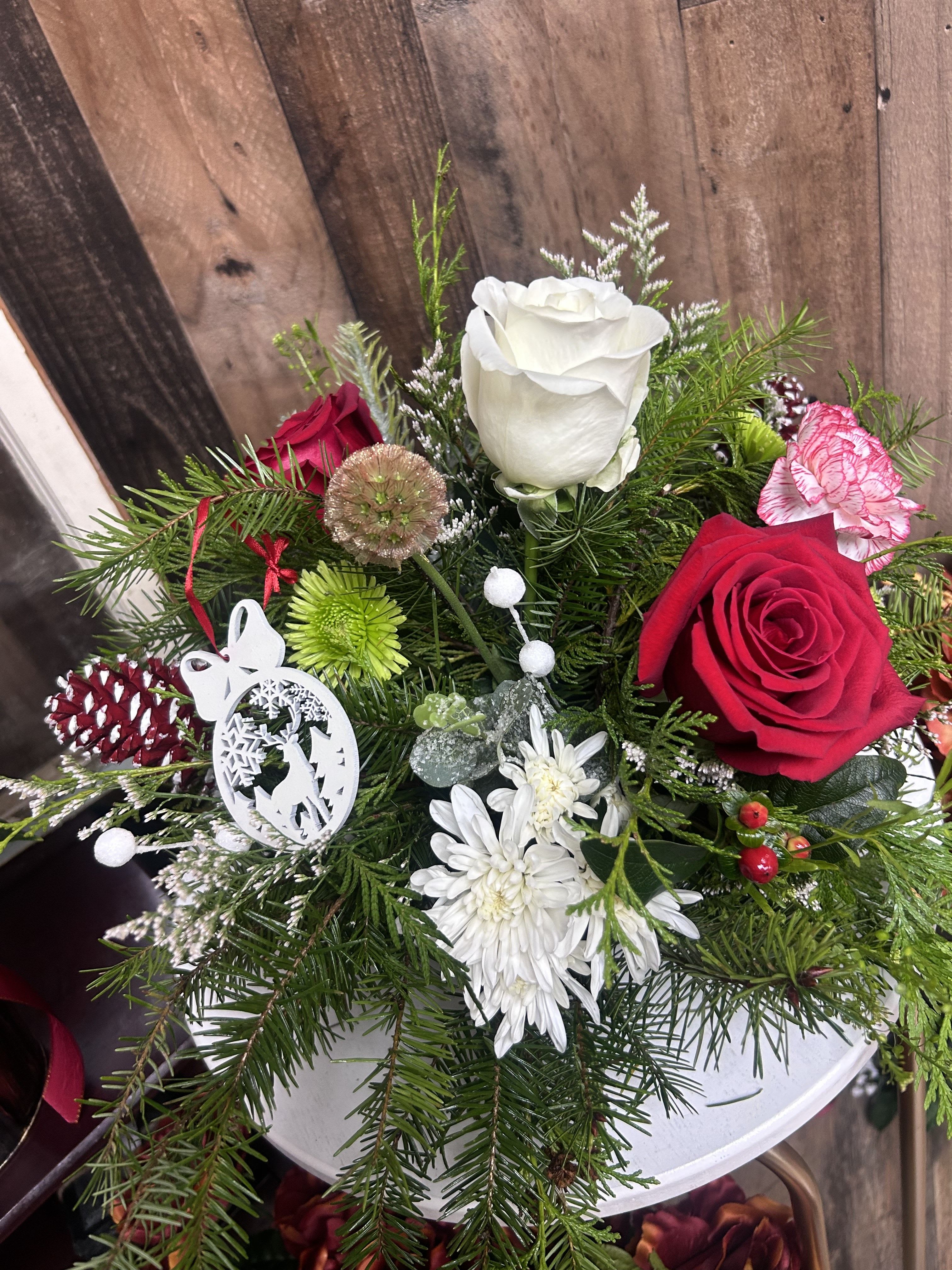 Christmas  - Holiday table centerpiece mixed with colorful flowers to bring in festive cheer.