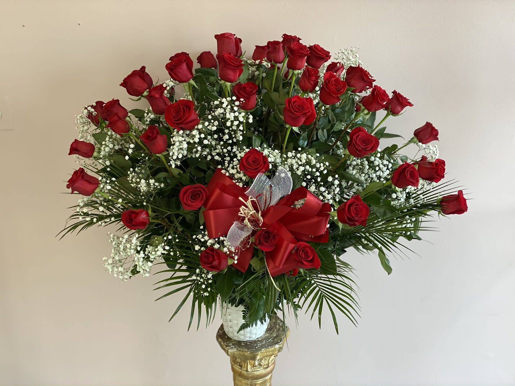 Large bouquet of red roses with baby's breath in a vase