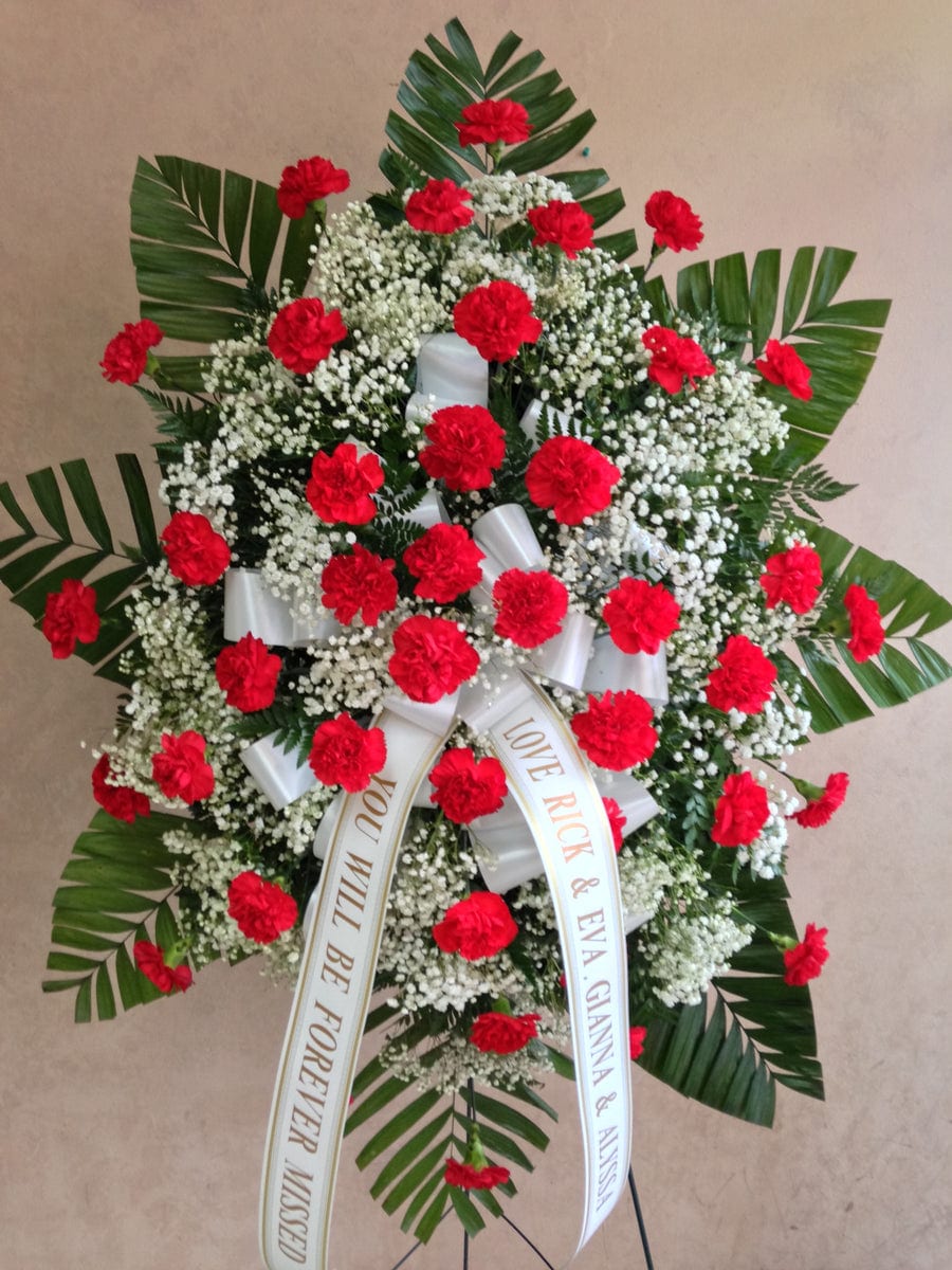Standing wreath of red carnations with white baby's breath and ribbon