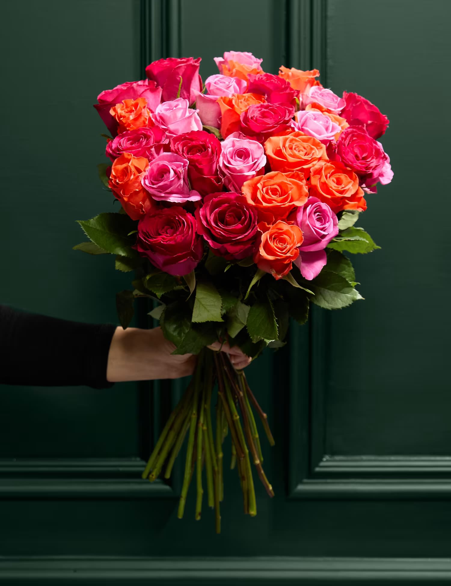 Handheld bouquet of pink, red, and orange roses