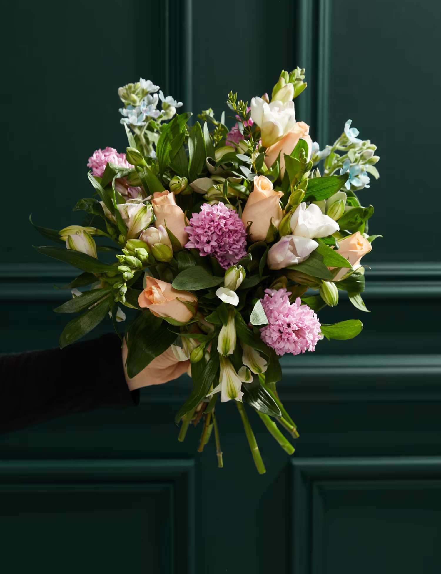 Hand-tied bouquet of peach and white flowers with pink blooms