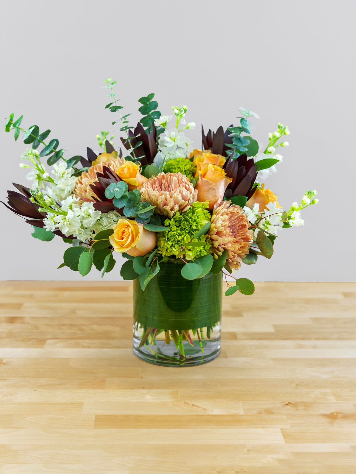 Bouquet of peach roses and chrysanthemums in a glass vase