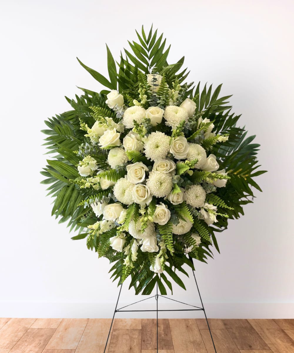 White floral standing spray with roses and mums on an easel