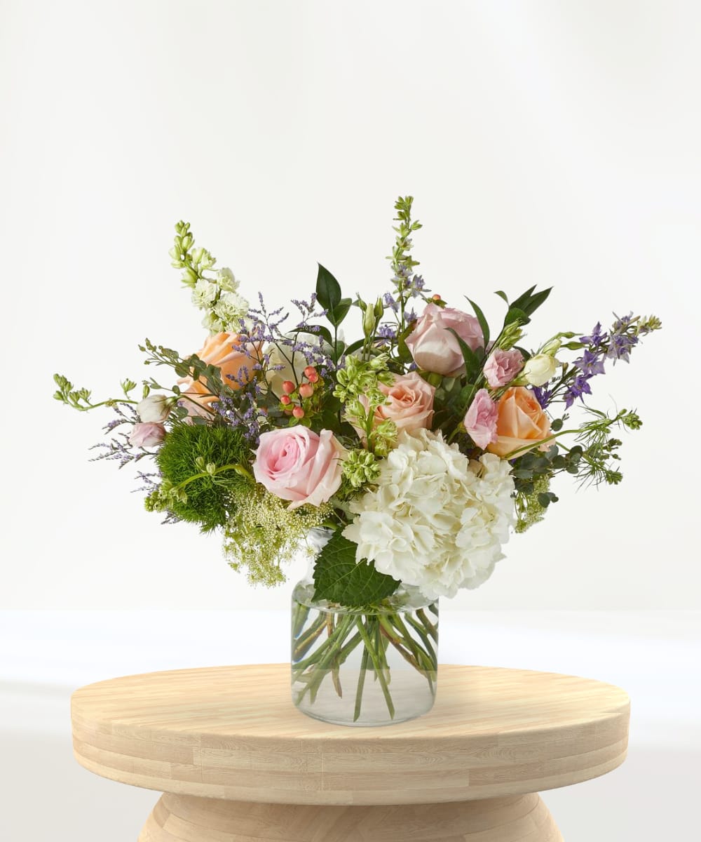 Bouquet of pink, peach, and white flowers in a clear glass vase