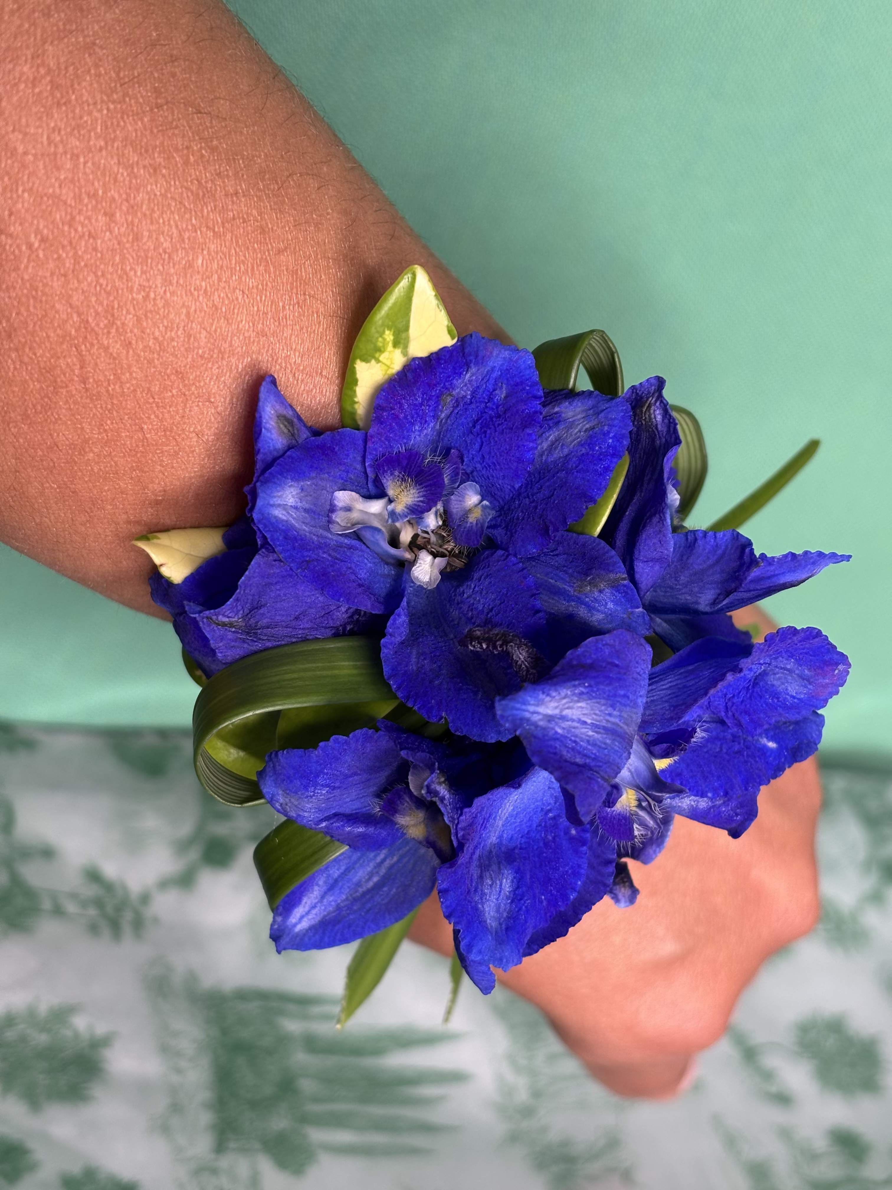 Blue flower wrist corsage with ribbon on a wrist