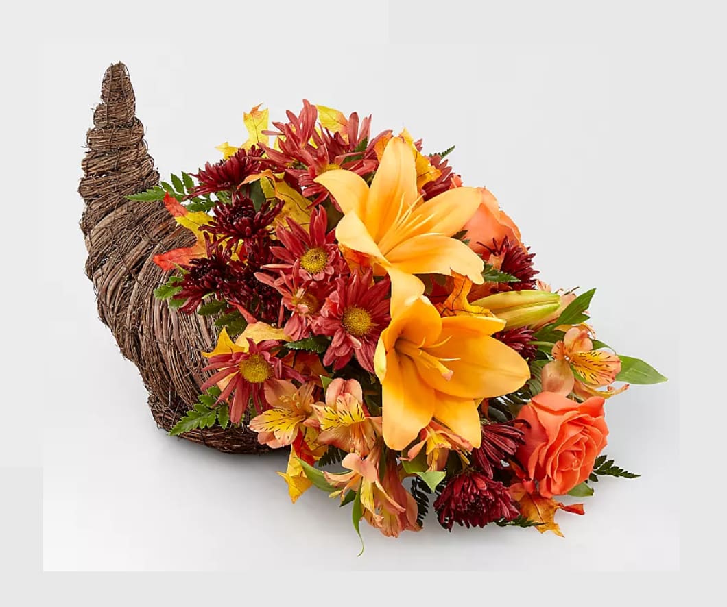Cornucopia Arrangement - This holiday cornucopia is the perfect gift for family gatherings. This tabletop centerpiece is made with fresh cut alstroemeria, daisies, roses and lilies. 