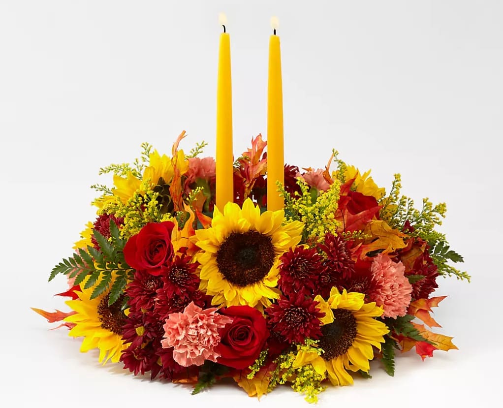 Sunny Centerpiece with Candles - A traditional round shaped tabletop candle centerpiece for the holiday season. Made with fresh cut daisies, roses, coffee beans and autumn leaves.