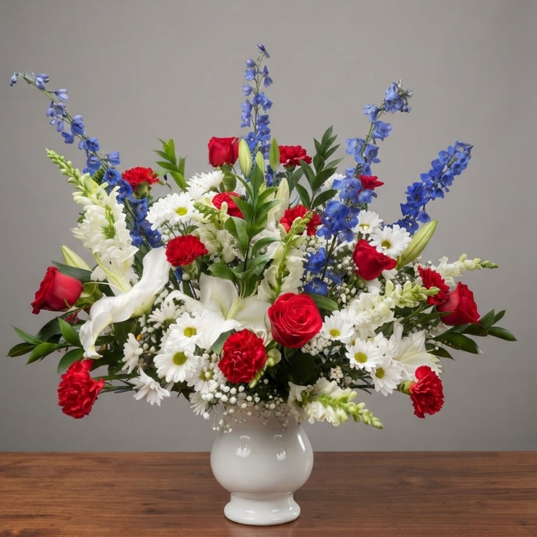 Red, white, and blue mixed bouquet in a white vase