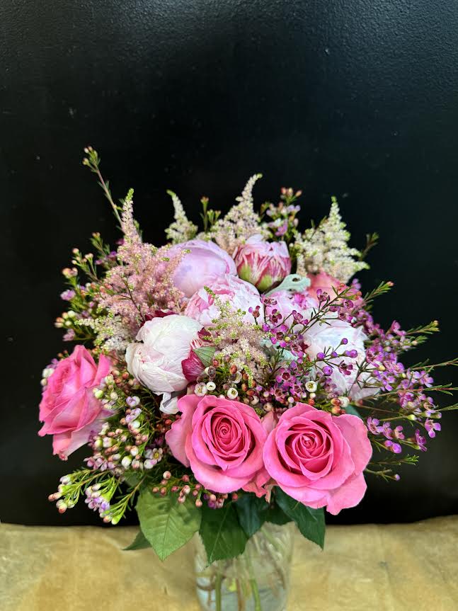 Pink and white bouquet of roses and peonies in a glass vase