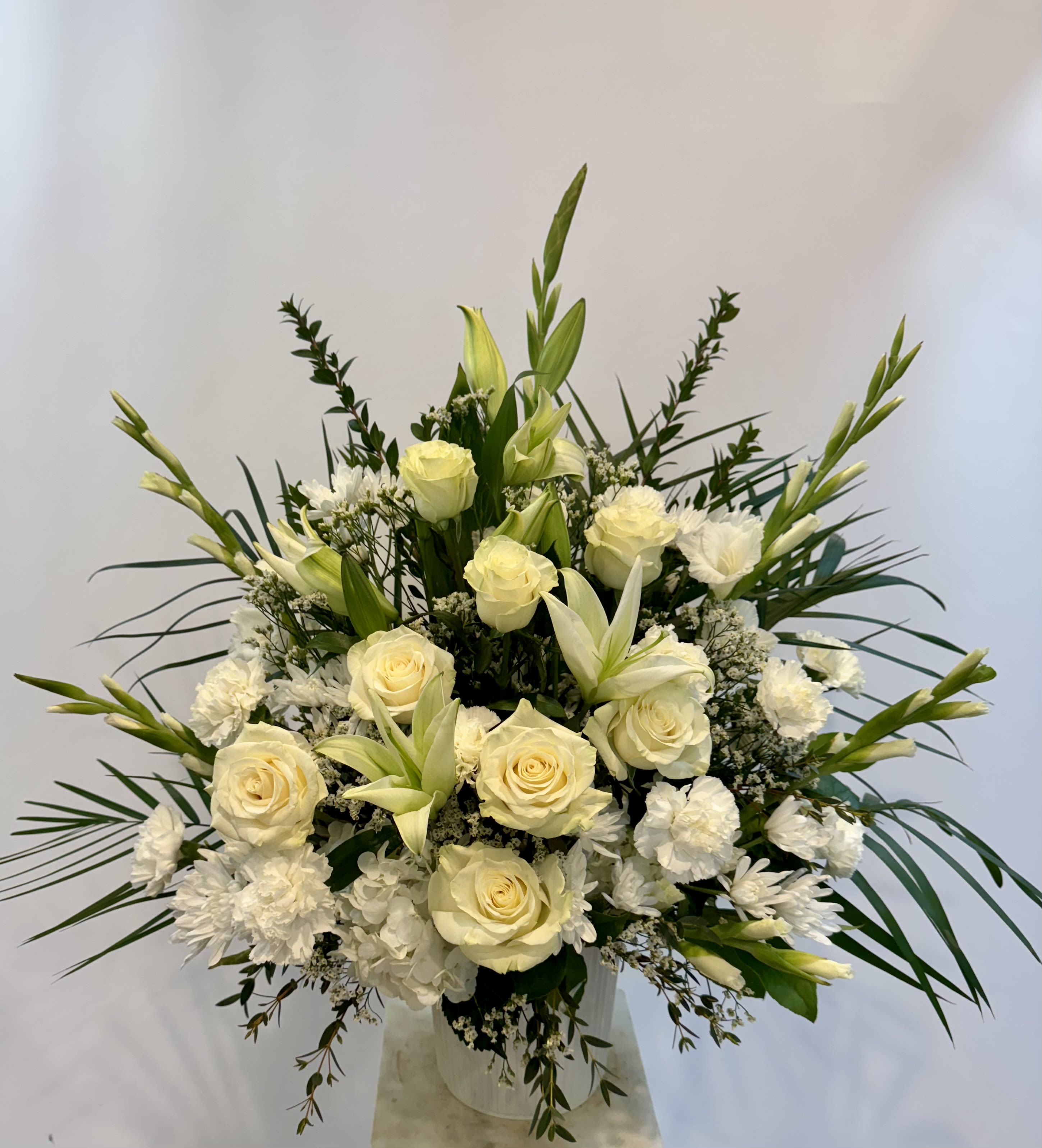 White roses and lilies arranged in a clear vase