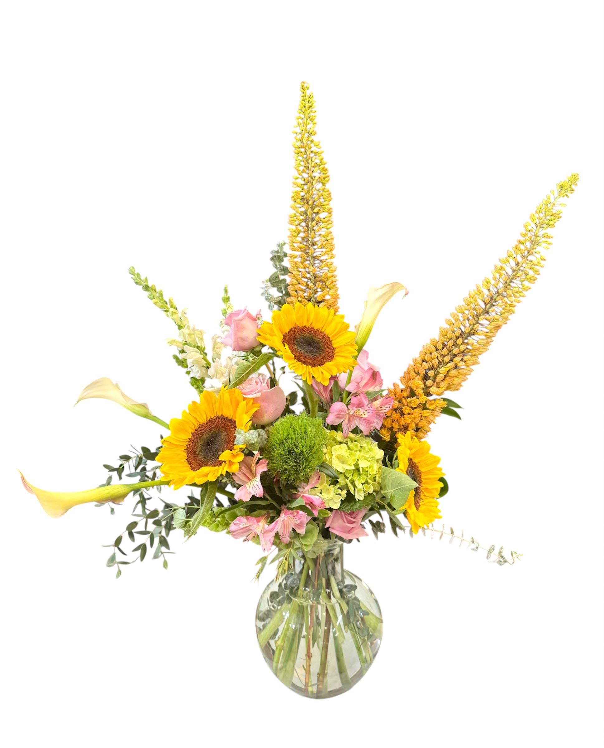 Sunflowers, pink blooms, and calla lilies in a glass vase