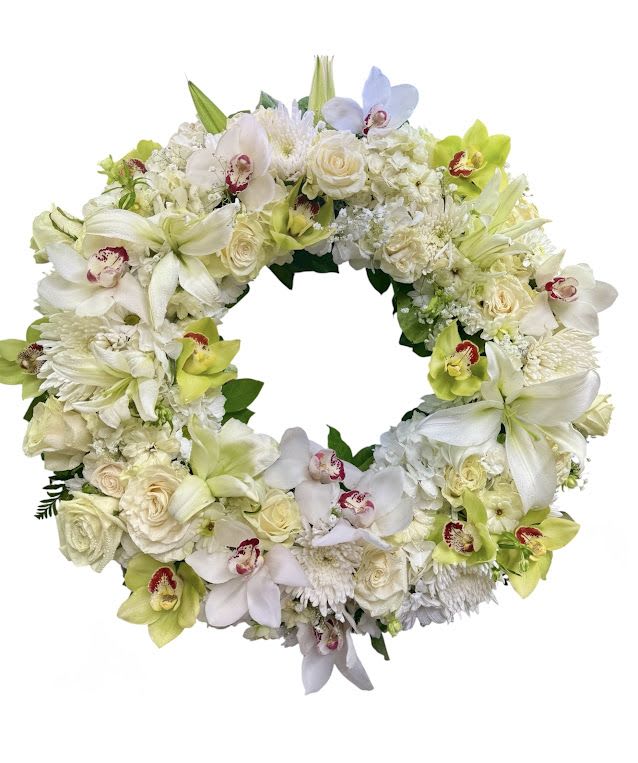 Circular floral wreath of white and pale green blooms with orchids and roses