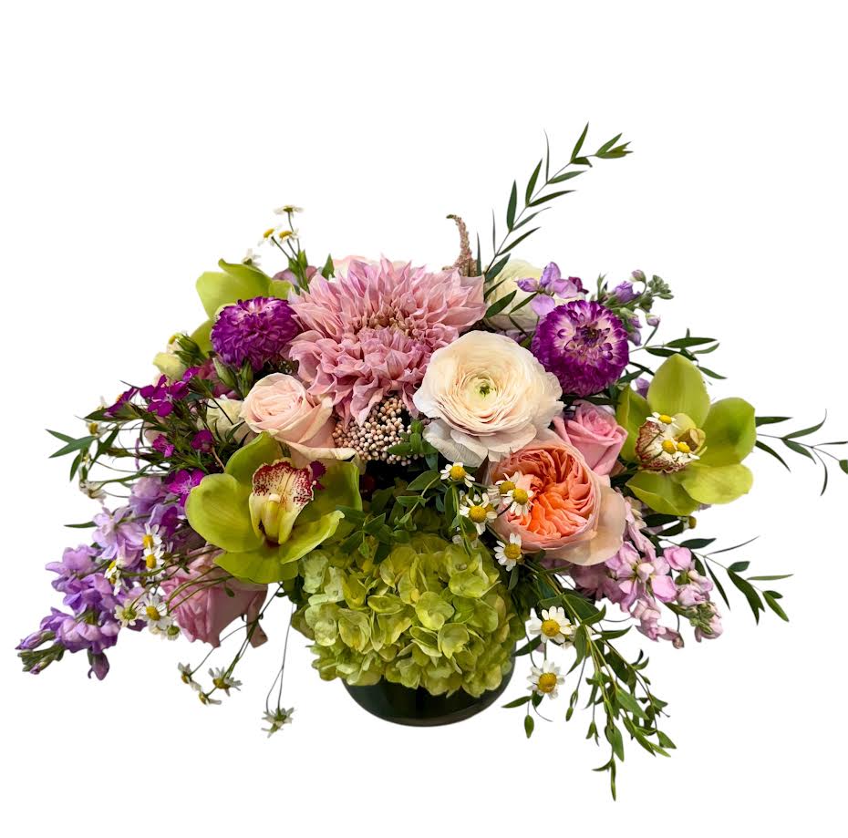 Mixed bouquet in a low black vase with pink, purple, and green blooms