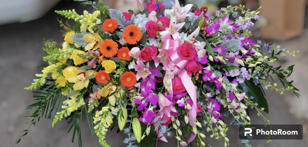 Colorful floral spray with roses, gerbera daisies, lilies, and orchids