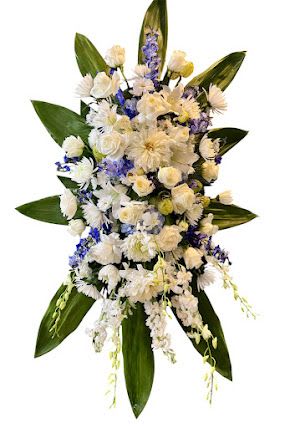White and pale yellow floral spray with blue accents and large green leaves
