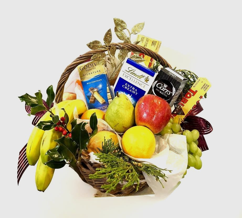 Fruit basket with chocolates and ribbon on a white background