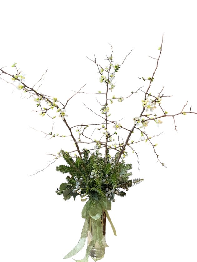 Tall branch arrangement with white blossoms in a glass vase