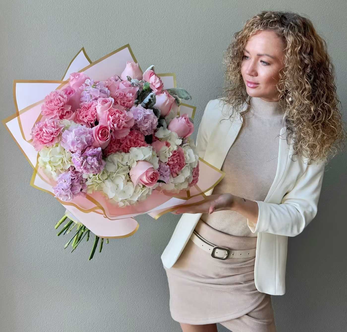 Large pink and white bouquet of roses and carnations wrapped in pastel paper