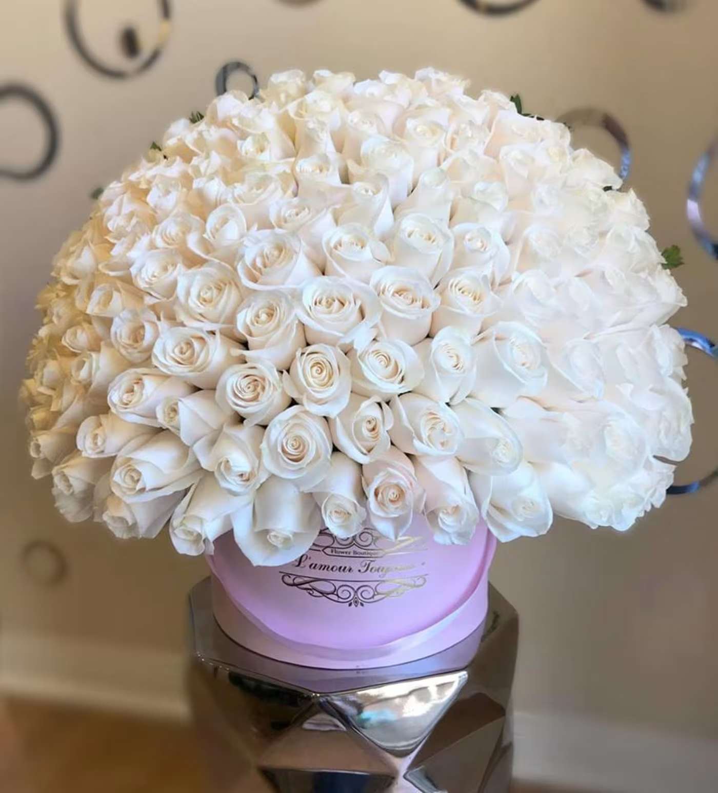 Large bouquet of white roses in a pink round box
