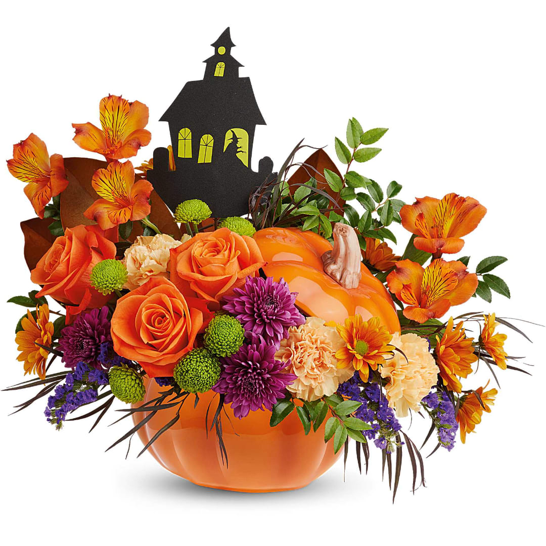 Halloween bouquet in an orange pumpkin container with a haunted house topper