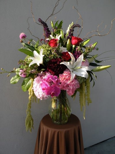 Tall mixed bouquet in a glass vase with white lilies, pink roses, and hydrangeas