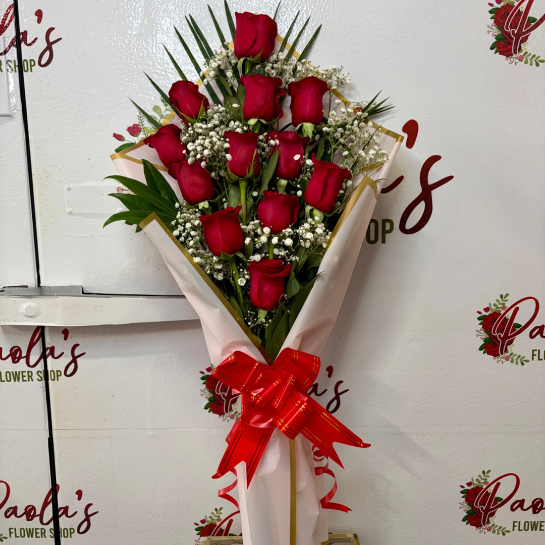 Bouquet of red roses with baby's breath wrapped in pink paper and a red ribbon