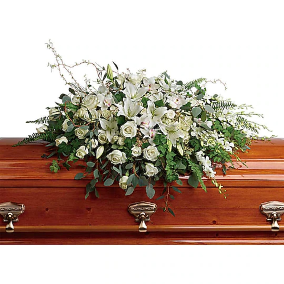 White floral spray on a wooden casket