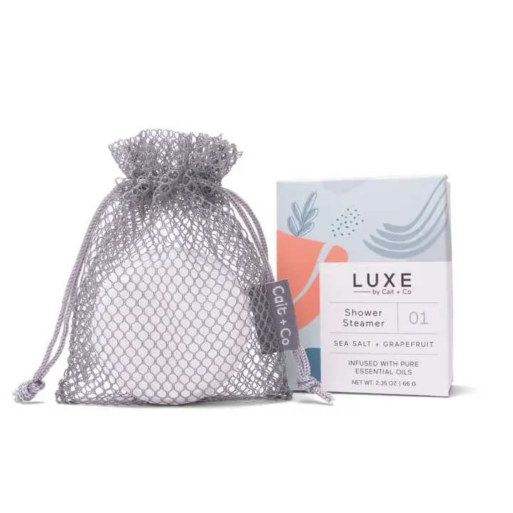 Mesh drawstring bag with a boxed shower steamer