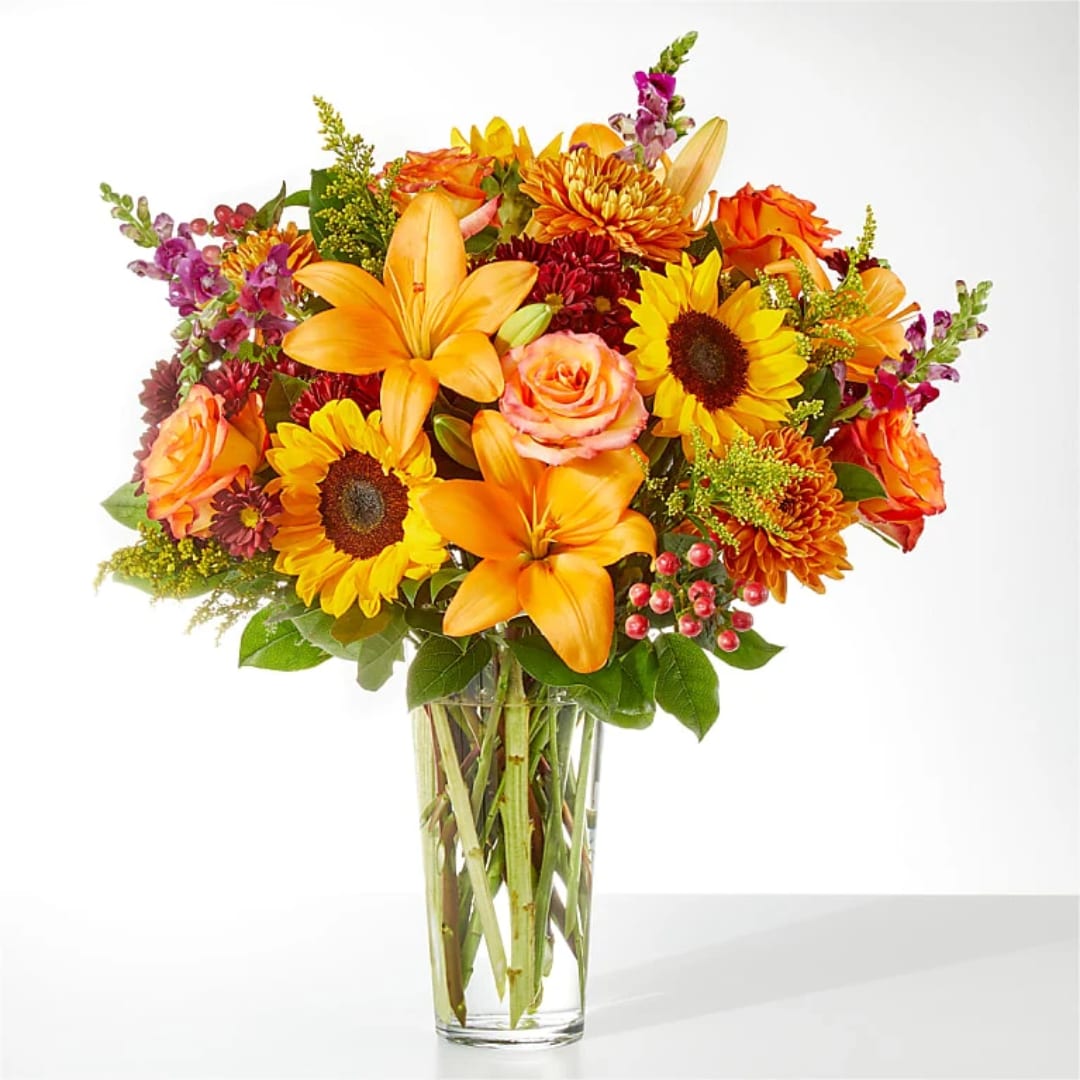 Orange and yellow mixed bouquet in a clear glass vase