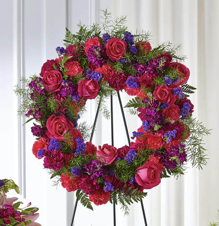 Heart-shaped floral wreath with pink roses and magenta carnations