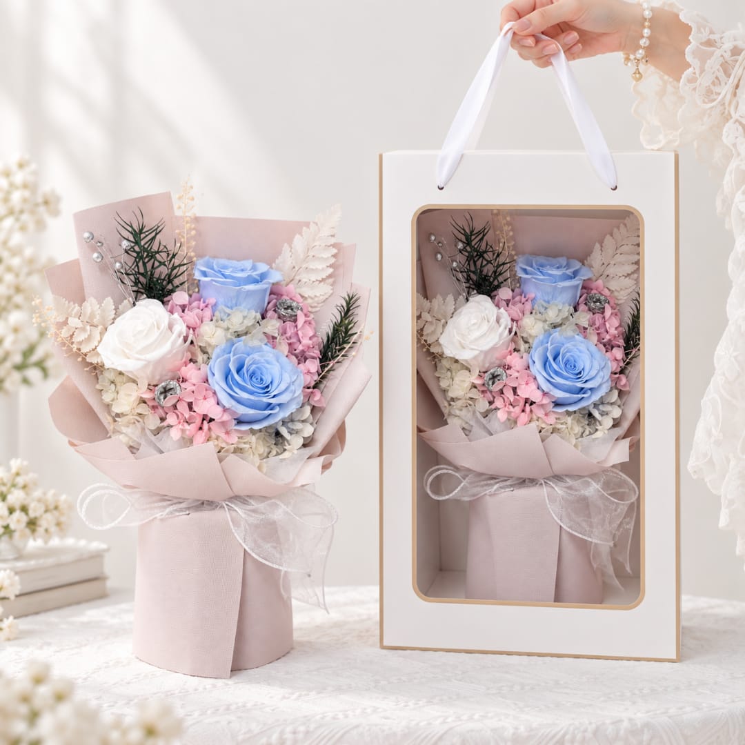 Bouquet of blue and white roses in pink wrapping, shown beside a gift box