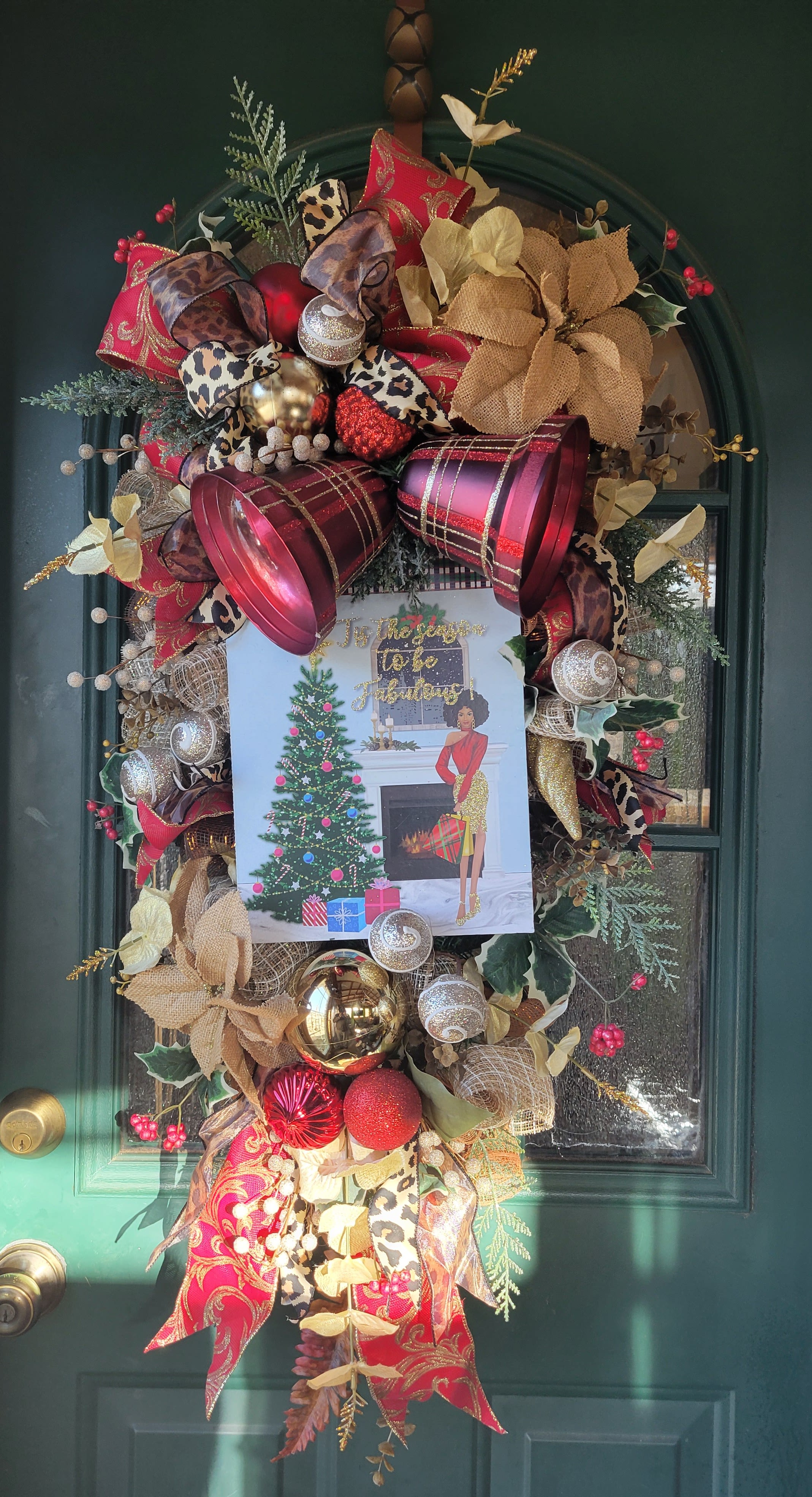 Decorated holiday wreath on a green door with ribbons and ornaments