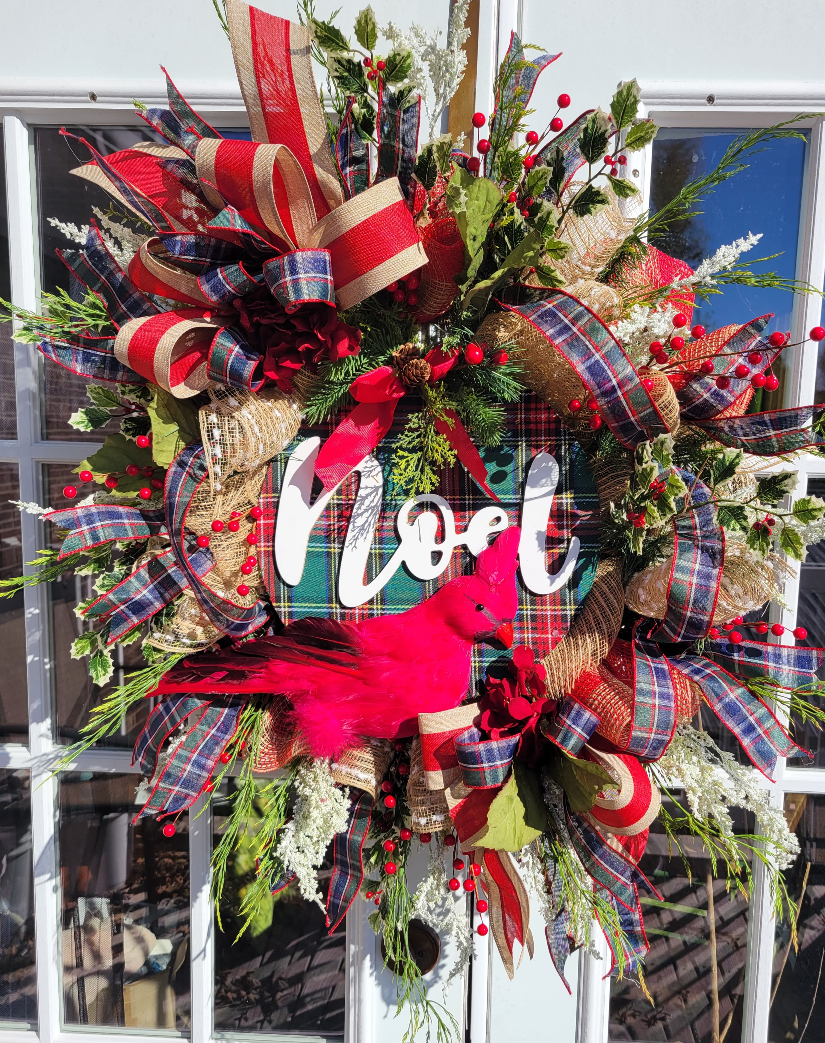 Christmas wreath with plaid ribbons, berries, and a pink bird